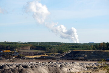 Braunkohlentagebau in der Lausitz mit Rauchwolken eines Kraftwerkes im Hintergrund