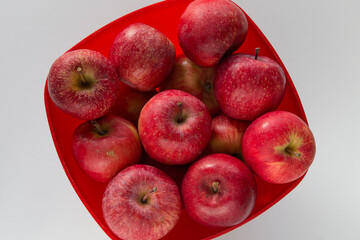 Cesto rosso con mele rosse su superficie chiara