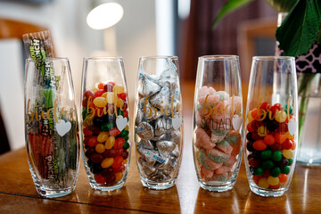 Close up photo of transparent vases with colorful stones inside Wedding details Decoration of the wedding venue Decorative stones in a transparent glass Close up 