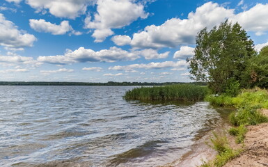 Summer landscape with river, ferry, trees and sky with clouds