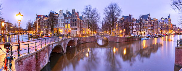 Panorama of Amsterdam canal Keizersgracht with typical dutch houses and bridge during morning blue hour, Holland, Netherlands