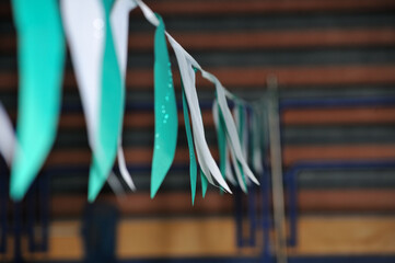 Selective focus shot of colorful triangular backstroke flags hanging over the swimming pool