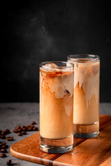Ice coffee in a glass with cream poured over.