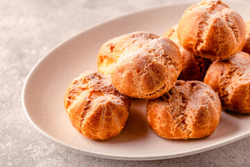 Homemade profiteroles with powdered sugar.