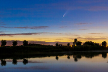 Meteor, shooting star or falling star seen in a night sky with clouds. Comet NEOWISE, C/2020 F3