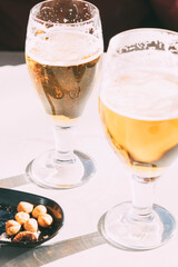 Two glasses of beer with morning sun.