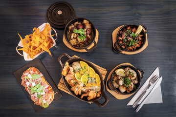 Traditional portuguese cuisine dishes of meat and fish products on a wooden table flat lay view