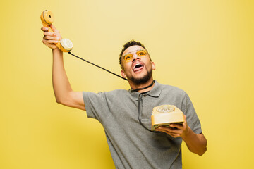 young african american man in sunglasses sticking out tongue while choking himself with telephone...