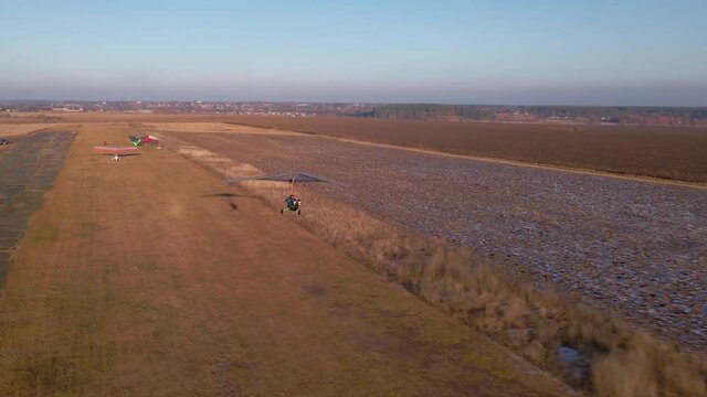 Hang glider trike take off from the airfield. Aerial footage