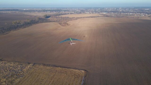 Hang glider wing lands on the airfield. Aerial footage