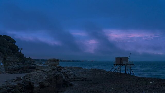 Lever de Soleil rose avec brouillard marin sur la ville de Royan, avec un Carrelets au premier plan et ciel rose, France