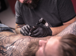Master of the art of tattooing creates a tattoo