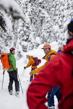 Happy Friends Backcountry Skiing In Snowy Winter Woods