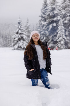 Portrait confident girl hiking in deep snow in winter woods