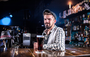 Bearded bartending makes a show creating a cocktail at bar