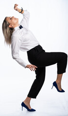 beautiful woman portrait in studio posing. a girl in a white shirt, bow tie, black trousers and stiletto heels smiles. white, isolated background