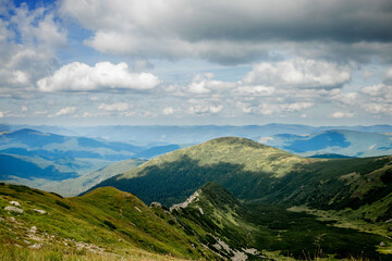 Fototapeta na wymiar Incredibly beautiful panoramic views of the Carpathian Mountains. Peaks in the Carpathians on a background of blue sky.