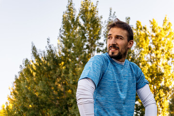 Obraz premium portrait of caucasian man in park with sportswear over a tree