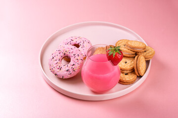 Pink creamy milkshake with strawberries and sweets