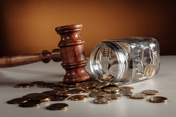 Glass jar with coins and wooden gavel