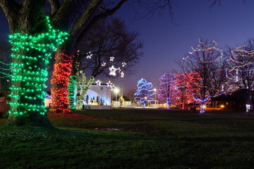 Holiday lights at night, tree with garland, Christmas installations