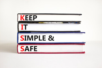 KISS keep it simple and safe symbol. Concept words KISS keep it simple and safe on books. Beautiful white table, white background. Business and KISS keep it simple and safe concept. Copy space.