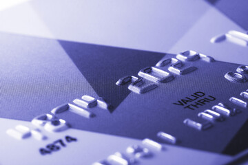 Fragment of credit card tinted in trendy color of 2022 by very peri