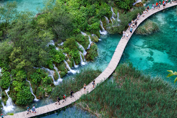 Aerial view at wooden hiking path through water besides waterfalls in Plitvice Lakes National Park,...