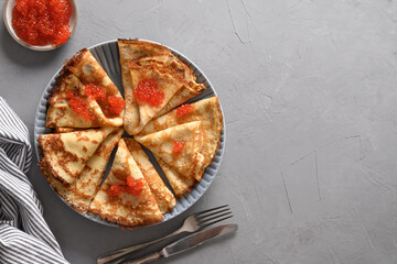 Russian thin pancakes or blini with butter on grey table. Top view. Shrovetide. Space for text.