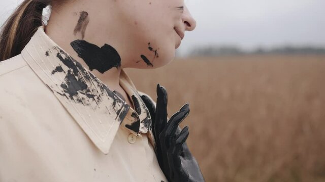 Graceful female hands covered with black paint in the dance leave marks on the body and clothing. Danger and fear concept. cocent of temptation. devils hand