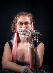 Professional tattooer with a tattoo gun in tattoo parlor