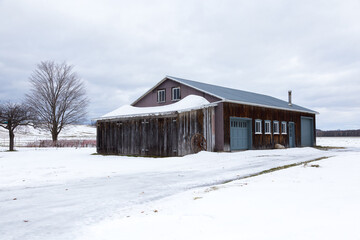 Large barn clad in old wood and metal seen during an overcast early winter morning, St. Augustin de Desmaures, Quebec, Canada