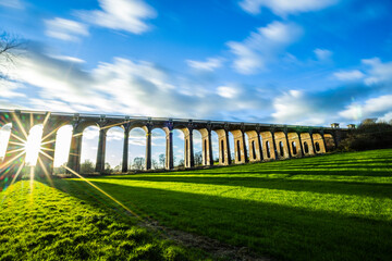 The Ouse Valley Viaduct in the late afternoon sun with clouds streaming overhead