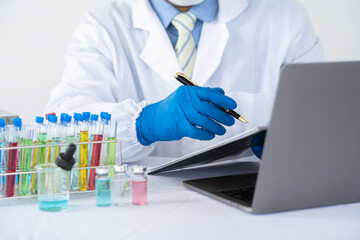 chemical researcher, scientist Analysis is taking notes on the results of the experiment. with...