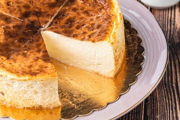 Sliced san sebastian cheesecake with coffee on wooden table
