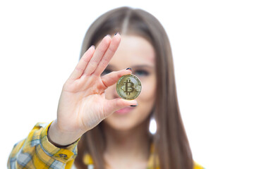 Close up shot of a physical bitcoin cryptocurrency held in front of a face in a hand of a beautiful...