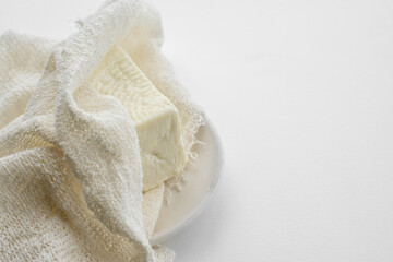 Fresh Adyghe cheese in gauze on a white background . Homemade farm food close-up