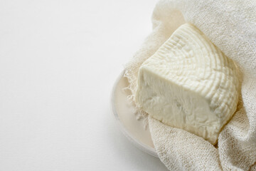 Fresh Adyghe cheese in gauze on a white background . Homemade farm food close-up
