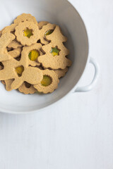 DIY Stained Glass Christmas Cookies in white china bowl on white background. Top view, flat lay composition with copy space. Food project. Indoor family activities.