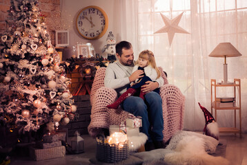 Merry Christmas and Happy Holidays! Dad and daughter decorate the Christmas tree indoors. The morning before Xmas. Portrait loving family close up. - 475603376