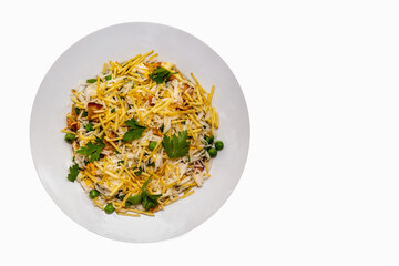 Biro-biro rice is a typical Brazilian dish to accompany or as a main course. Parsley, potato sticks, peas, egg, and bacon. Isolated in top view on round plate