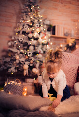 Merry Christmas and Happy Holidays! Little girl enjoying christmas indoors. The morning before Xmas. Portrait loving family close up. - 475603515