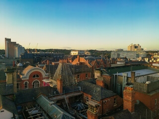Fototapeta na wymiar Nottingham cityscape at sunset. Industrial historical English city. Red brick buildings and clear blue sky.