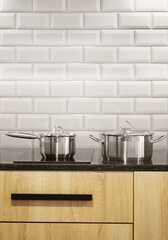 Steel pan and stewpan standing on kitchen stove