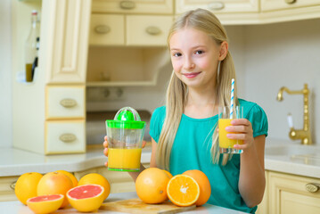 Teenage child makes orange and grapefruit juice from fresh produce