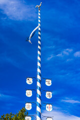 a traditional maypole in Munich with blue skies and sunshine