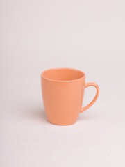 orange ceramic coffee mug on a light background