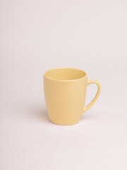 yellow ceramic coffee mug on a light background