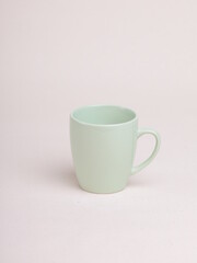 green ceramic coffee mug on a light background