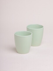 green ceramic cup on a light background